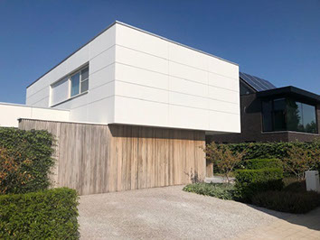 Moderne woning met witte gevelplaten en houten bekleding, een project van Ramon BVBA